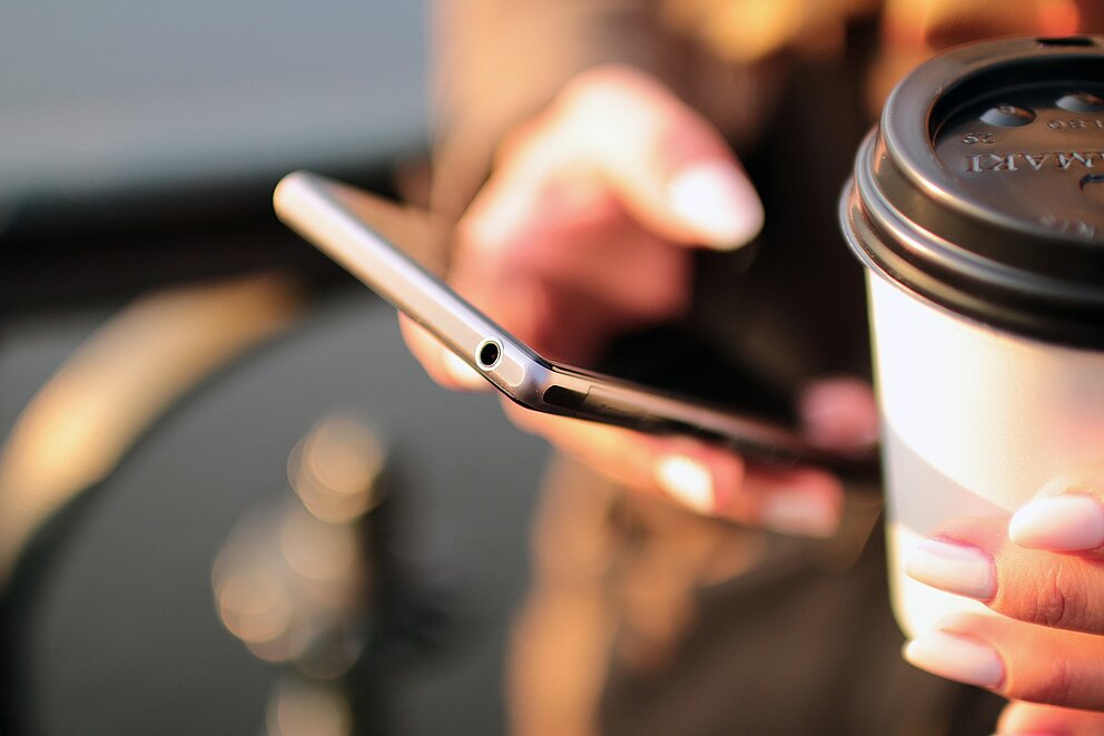 Hand hält Smartphone – Kontaktaufnahme mit WECOTEC GmbH leicht gemacht